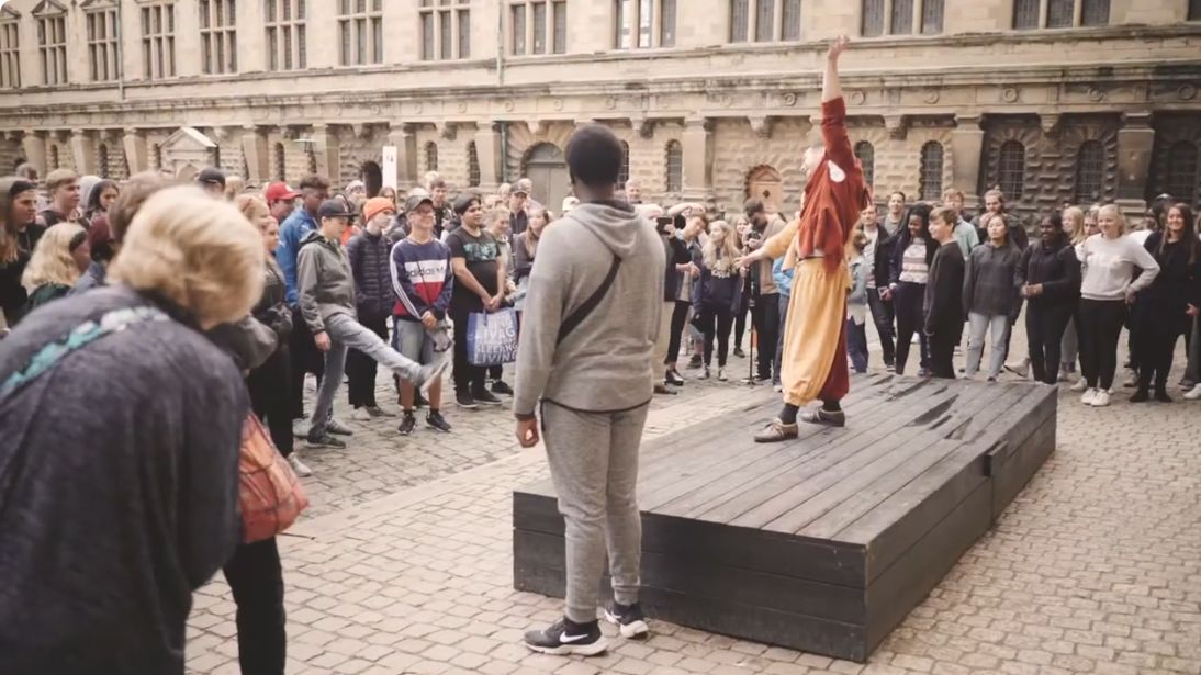 A Hamlet Live performer and visitors participating in Kronborg Castle’s courtyard
